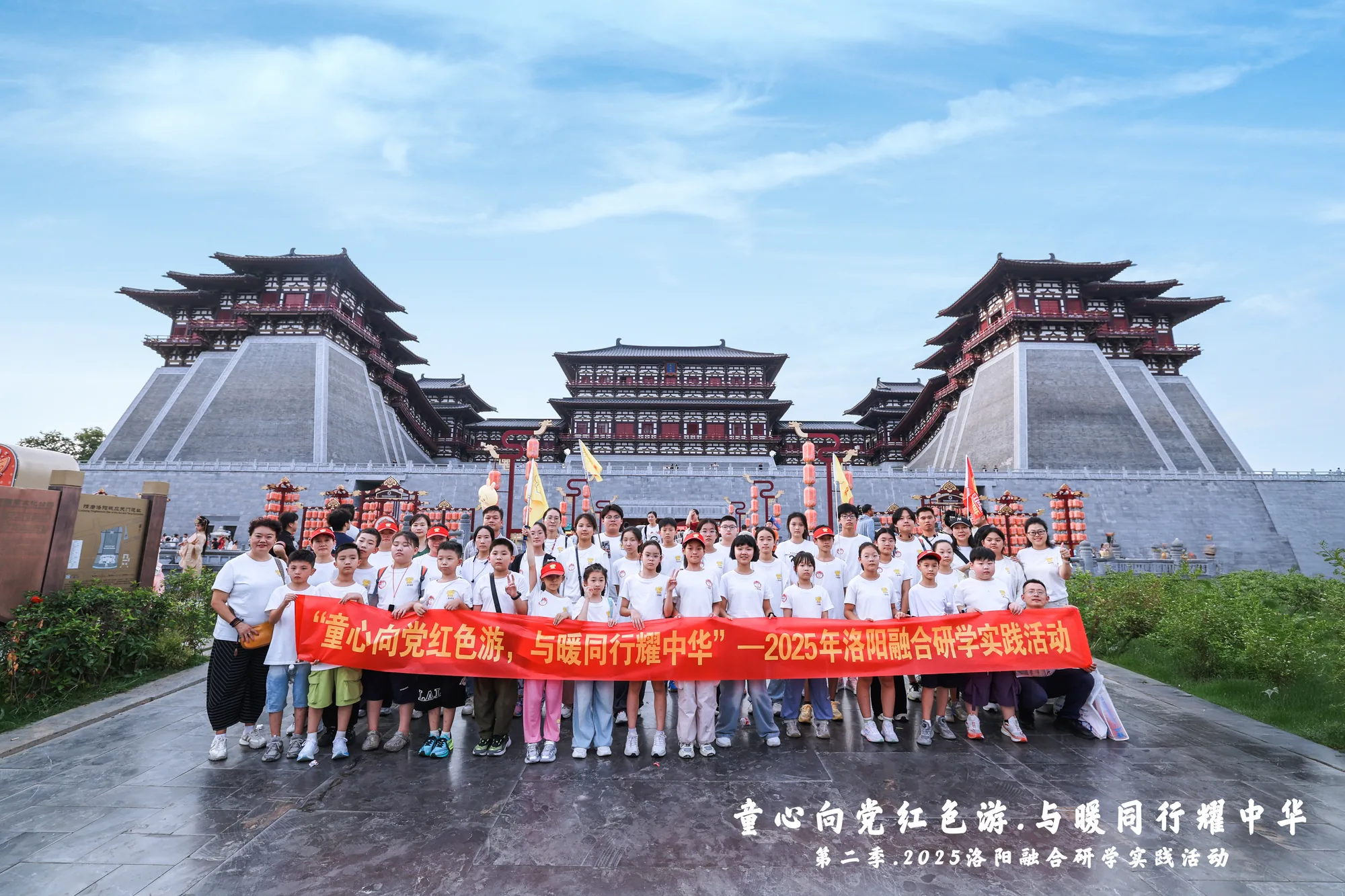 古城门前集体合影，成员手持红色横幅