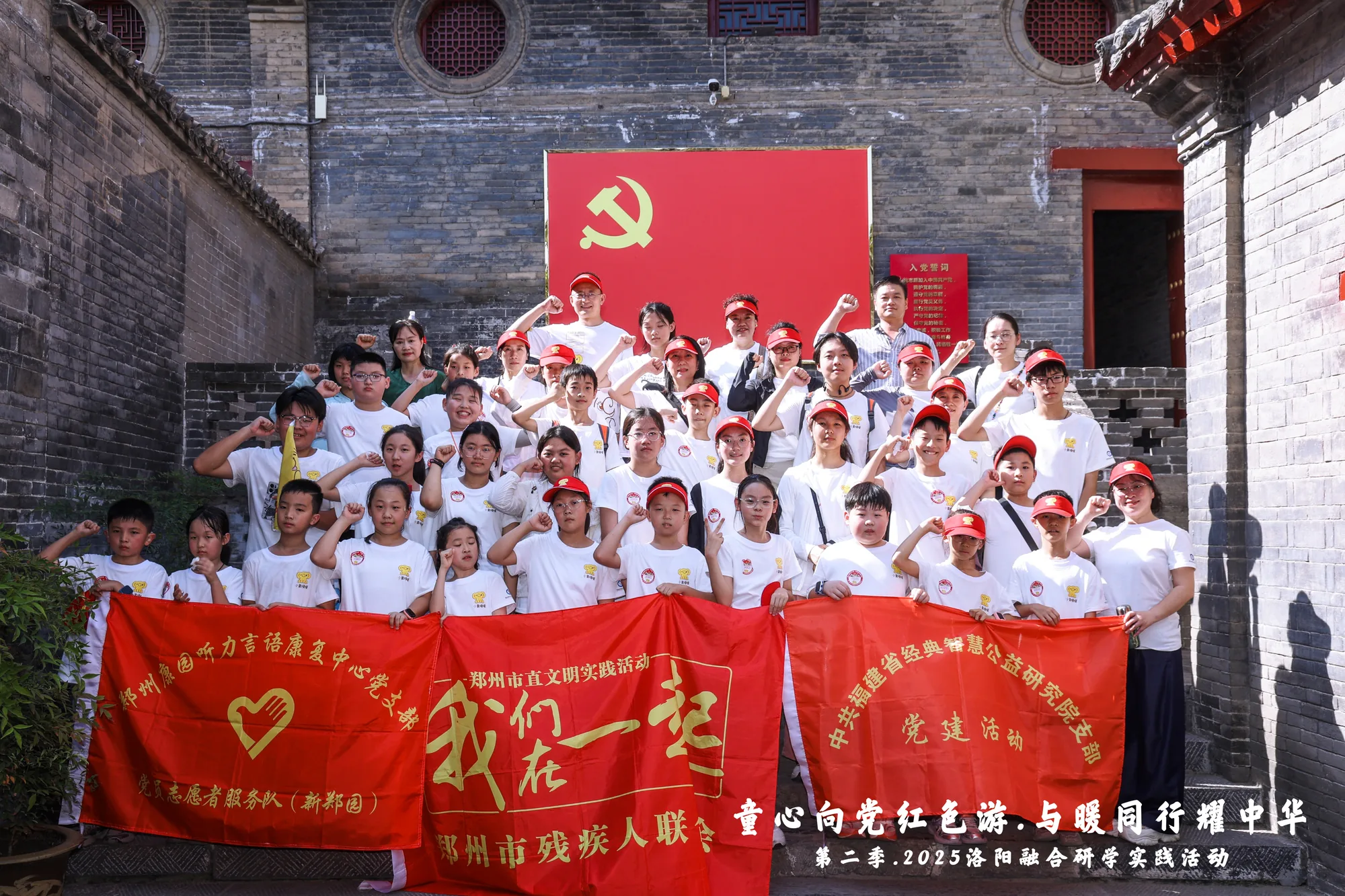 室内主题墙前集体合影，成员手举红心造型牌