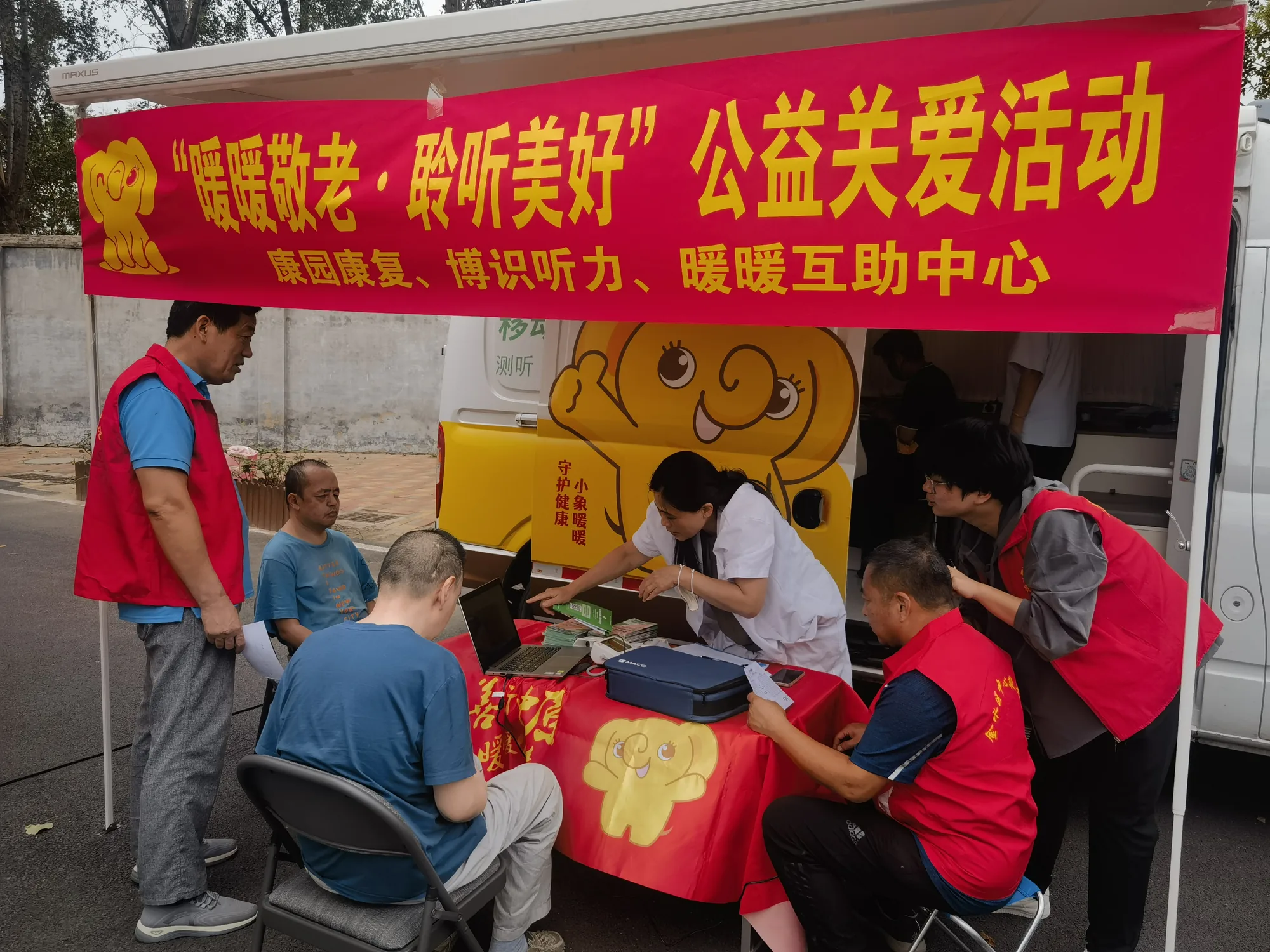 红马甲志愿者为老人提供听力检查