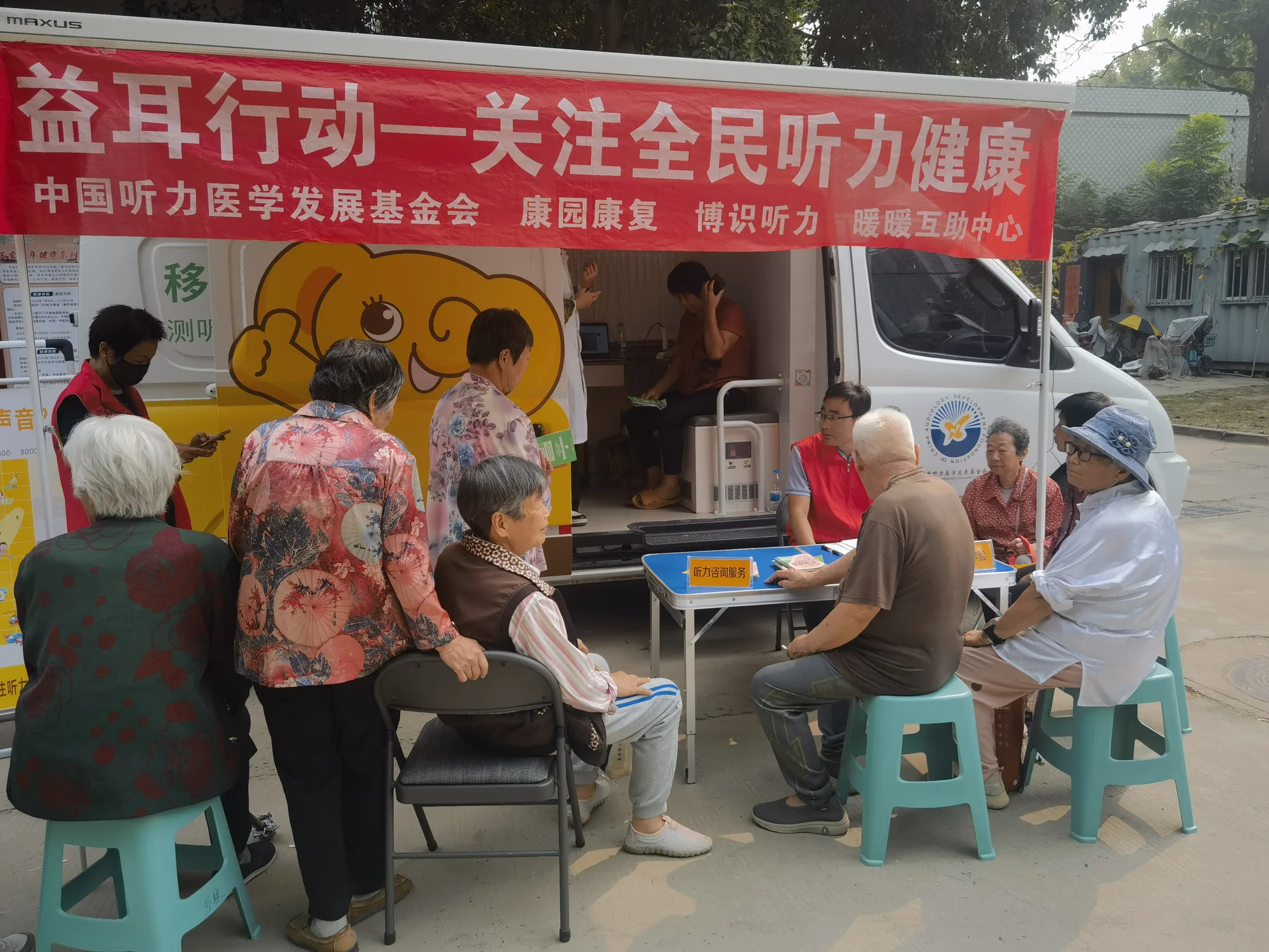 移动听力服务车前老人接受检查