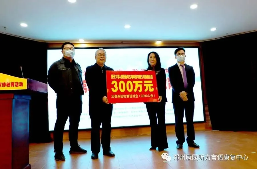 舞台四人共同手持「300万元」牌（耳聋基因检测服务捐赠）