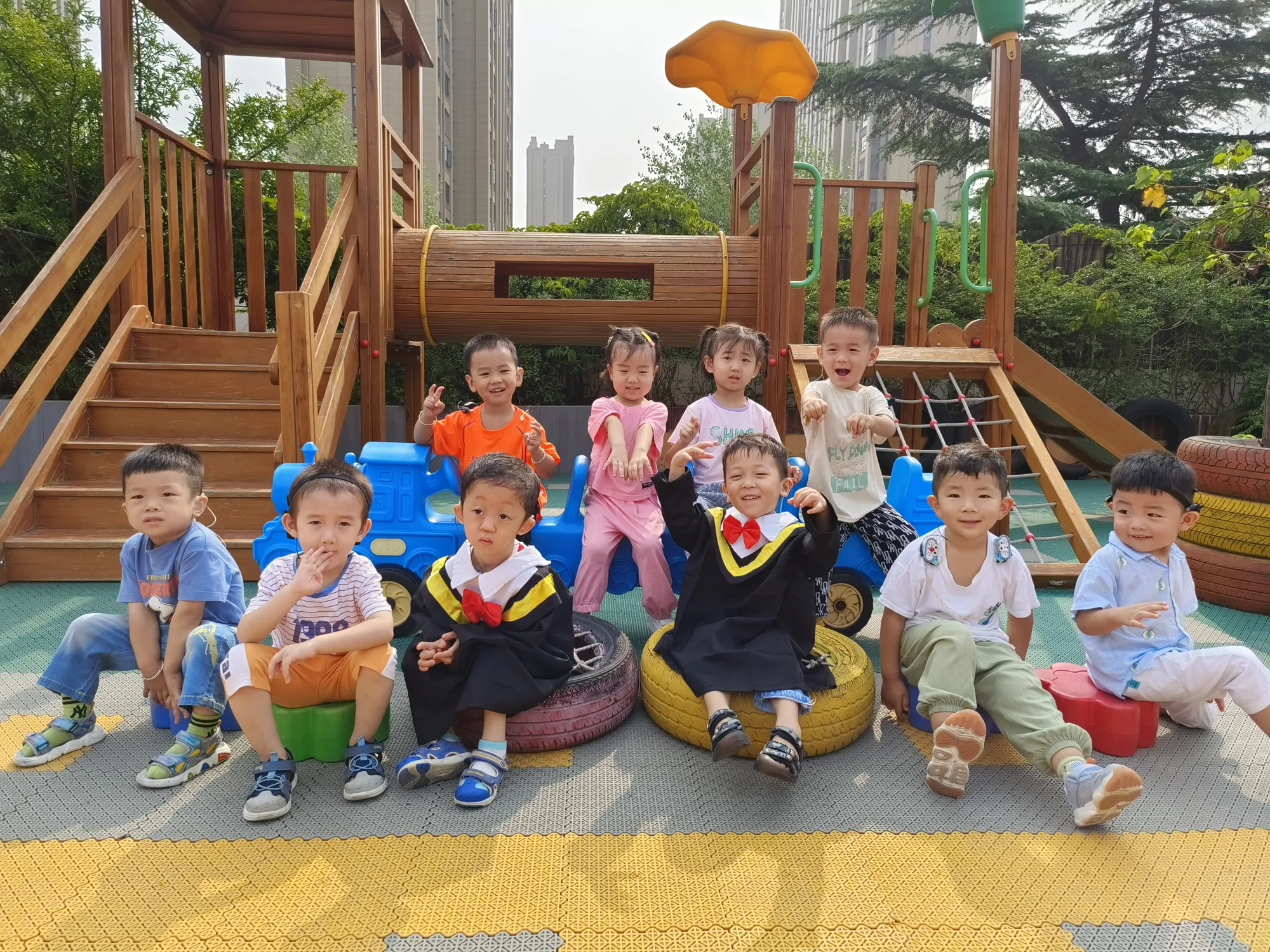 孩子们在户外游乐区坐轮胎凳合影